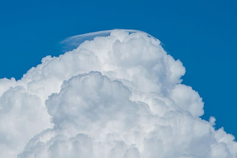 Pileus cloud: A towering white cloud has a thin white cap of cloud on the top.