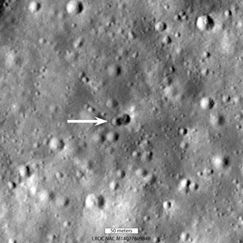 Gray cratered surface, with an arrow pointing to 2 small overlapping craters.