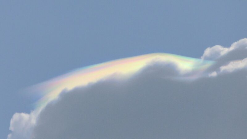 A large gray cloud with the top edge covered in a thin iridescent cloud.