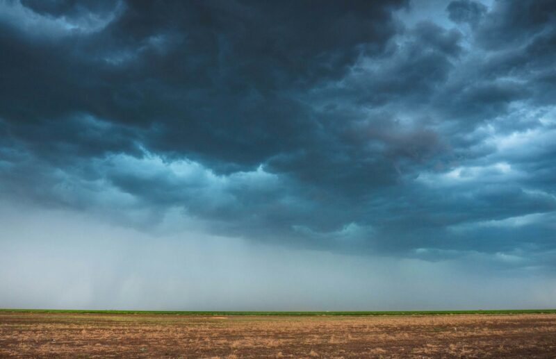 Dark blue clouds above the brown ground.