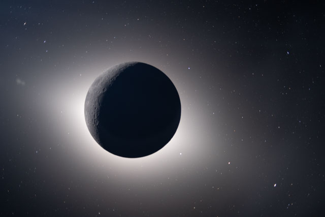 A black sphere in space, with some markings on the top left and a glow all around it, with some stars.