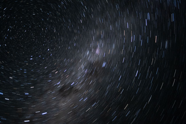 Fuzzy band across dark space with many short, bright concentric lines.