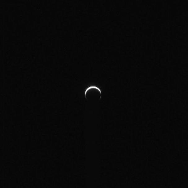 Psyche mission: A thin crescent with the lit side pointing up in the darkness of space.