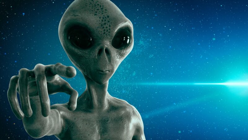 Classic-looking gray alien with a big bald head and large eyes, pointing a finger.