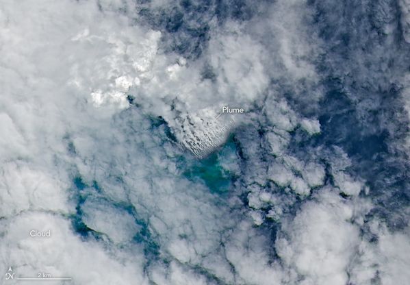 Satellite view of clouds over blue sea with multiple small-looking parallel white streamers.