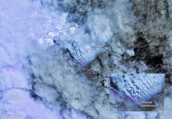 Satellite view of clouds over blue sea with multiple small-looking parallel white streamers and enlarged inset.