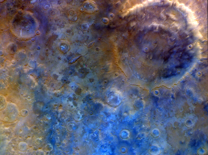 Blue and tan colored terrain with different sized craters.
