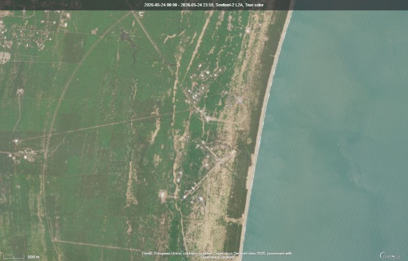 Water on left and thin roads in tan stretching from green land to tan waterfront regions.