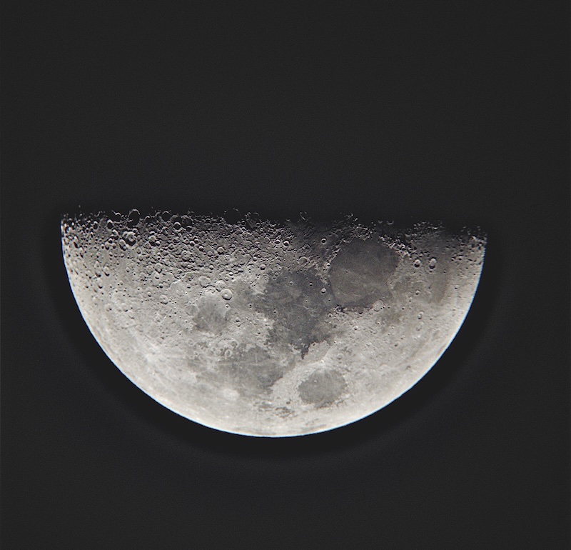 First quarter moon against a dark sky.