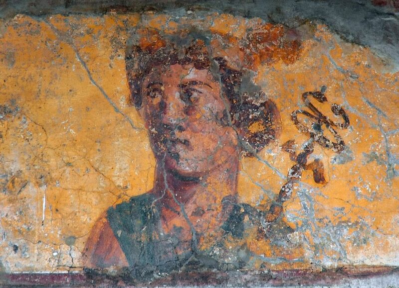 Painting on a wall of a man with curly hair holding a kind of scepter.