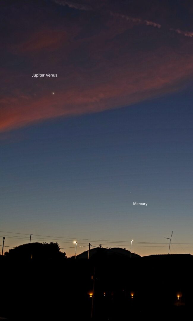 Through clouds, 2 bright dots, and much closer to the horizon a dim dot, all  in the twilight sky.