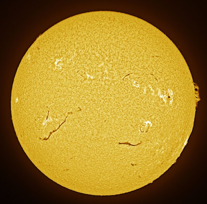 The sun, seen as a large yellow sphere with a mottled surface.