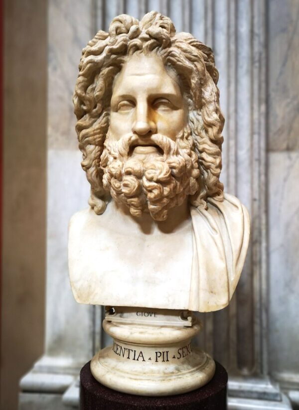 A bust of a man with a bushy, curly beard and full curly hair.