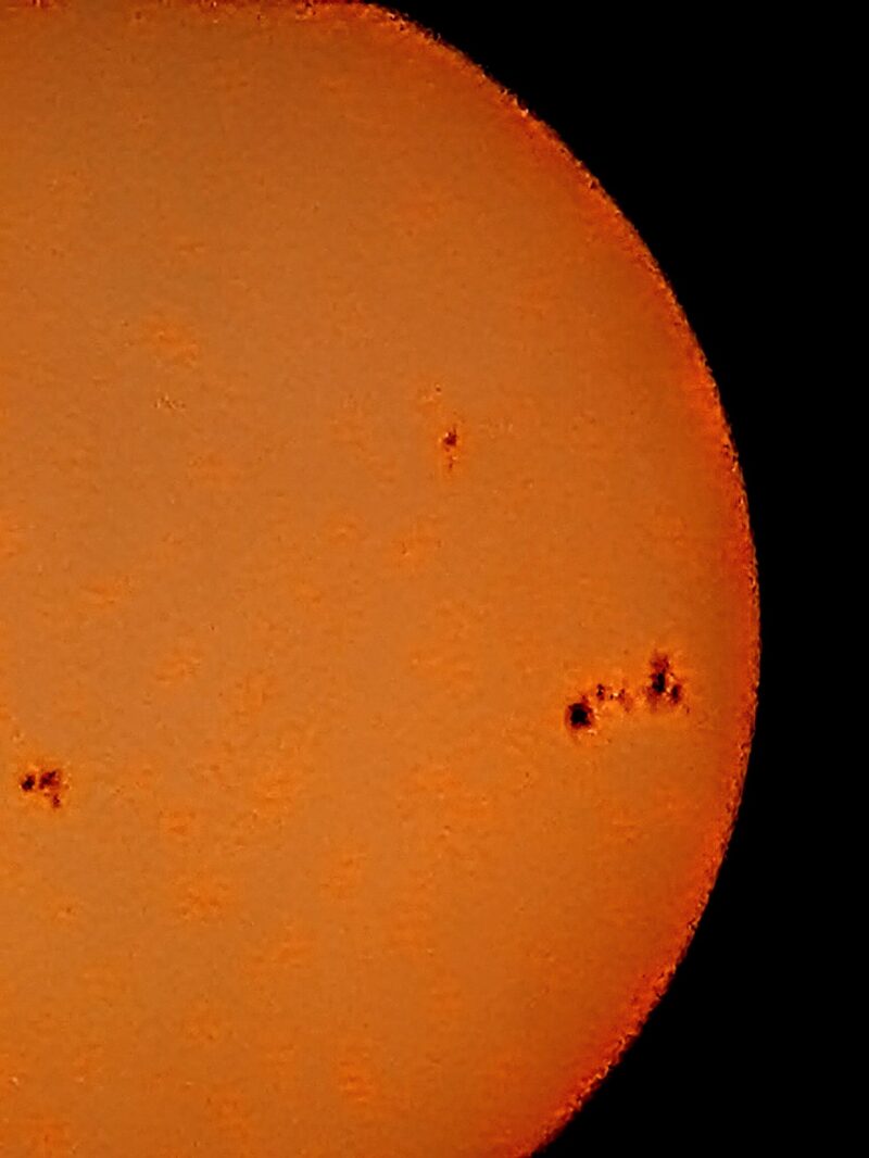 The sun, seen as a yellow sectional sphere with dark spots.