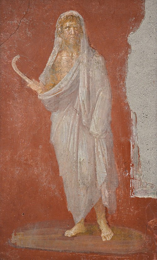 A painting of a man draped in white holding a curved stick done on a wall.