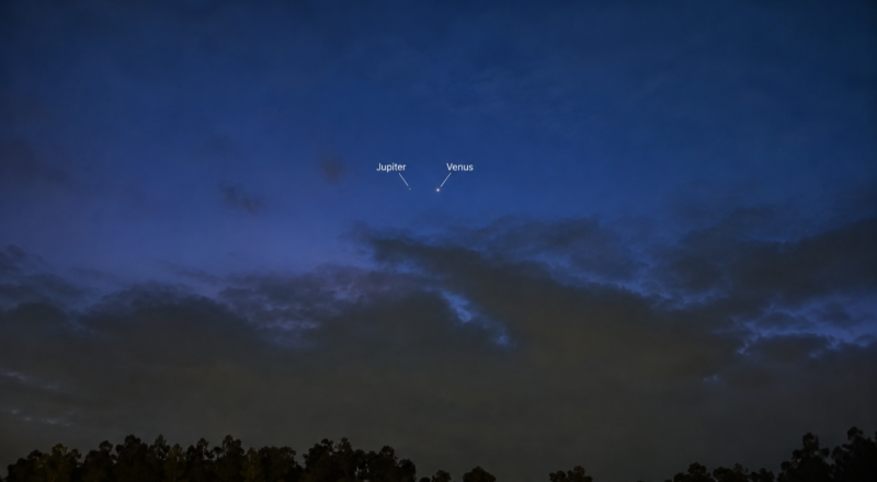 2 bright dots next to each other in a dark blue sky. There are dense clouds below.