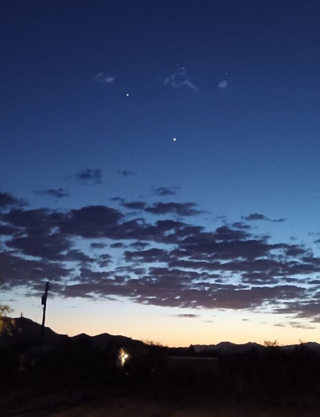 2 very bright dots in the sky, and 2 fainter dots above. Puffy clouds below.