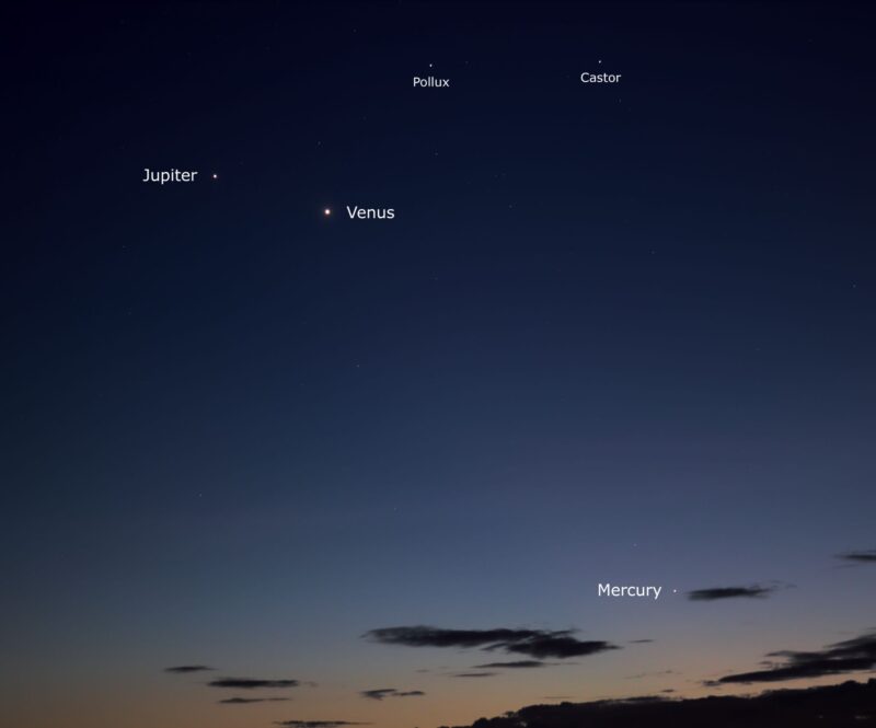 3 planets and 2 stars in a dark blue sky. Some clouds below.