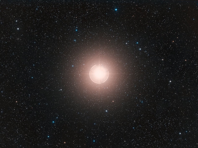 Starry sky with a bright sphere in the middle that is the star Betelgeuse.