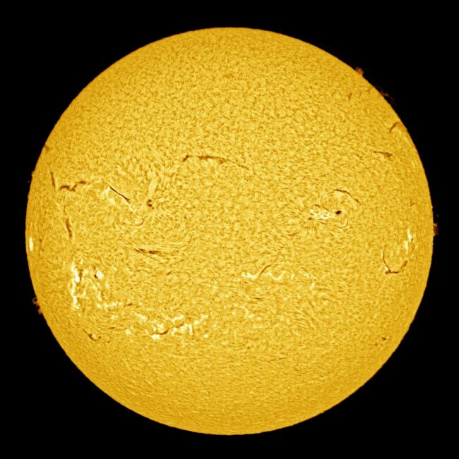 The sun, seen as a large yellow sphere with a mottled surface.