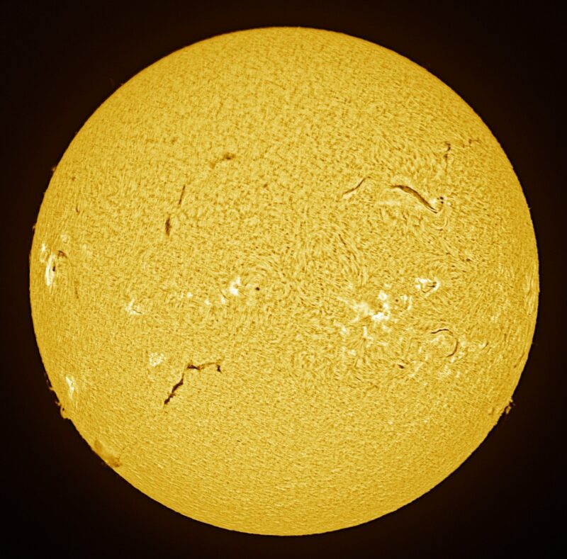 The sun, seen as a large yellow sphere with a mottled surface.