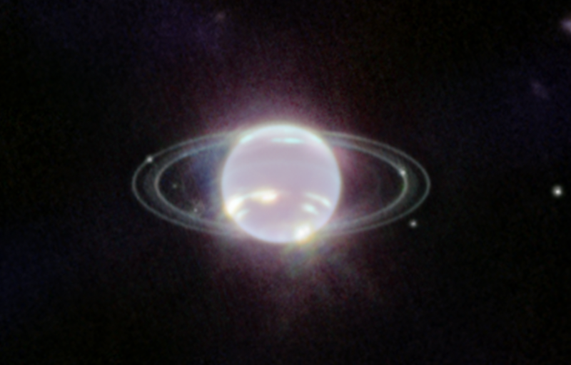 Neptune's inner moons: Hazy-looking planet with rings and several small moons near it.
