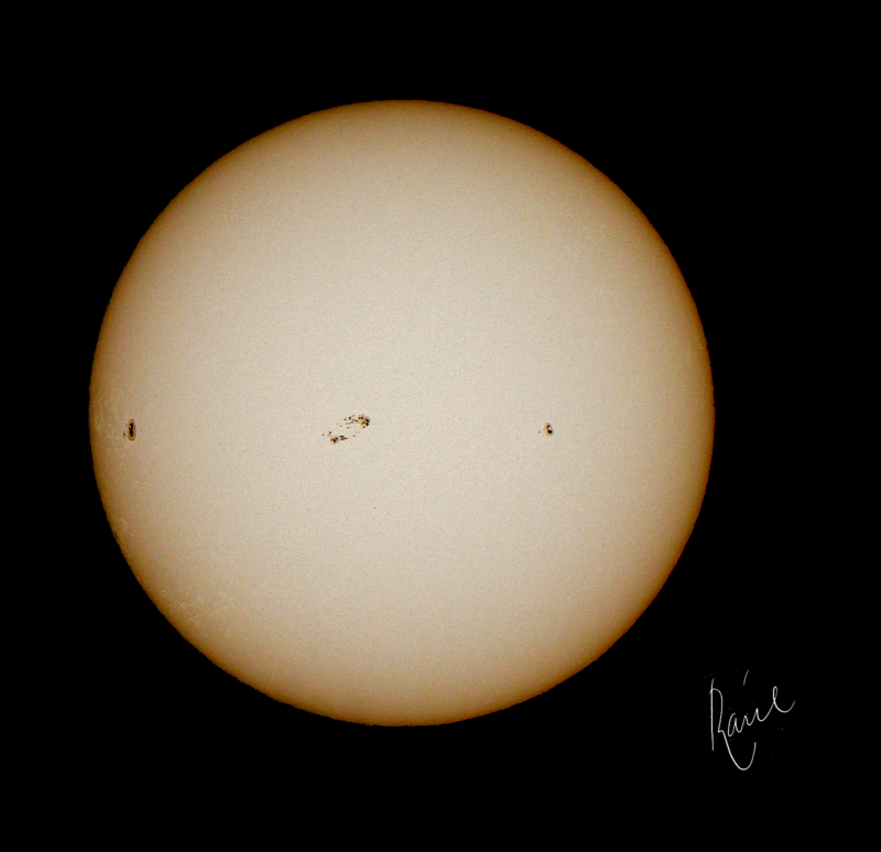 The sun, seen as a yellow sphere with dark spots.