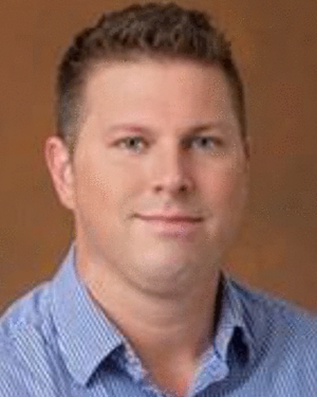 Smiling man with short hair.