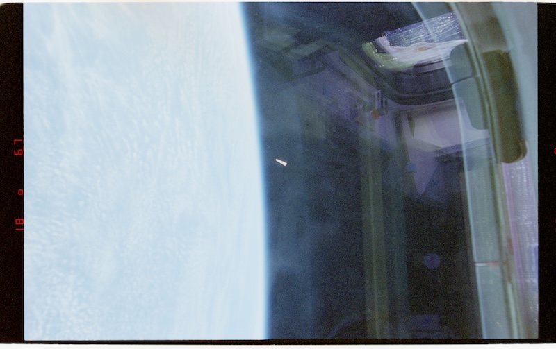 Pentagon UAP files: View of Earth through window on spacecraft. A small triangular object is in the distance.