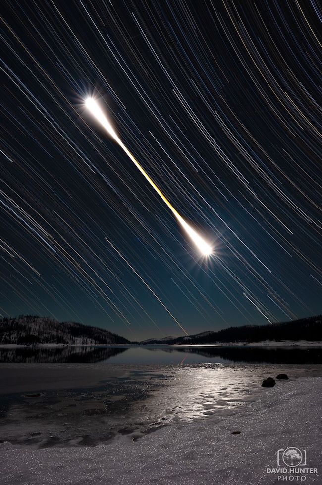 Star trails with a bright Q-tip shaped white trail that is the moon during a lunar eclipse.