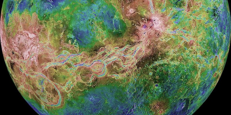 Rift valleys on Venus: Partial view of rocky planet with patches of blues and greens. Long valleys stretch across the middle regions.