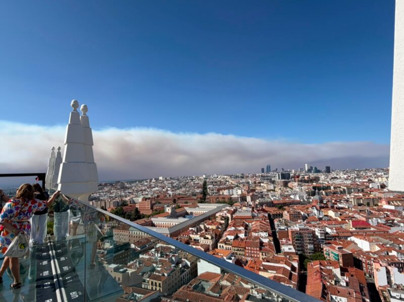 View from a rooftop of dense smoke beyond a city view.