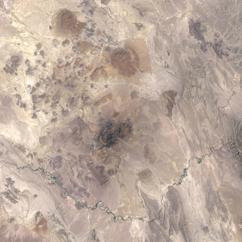 Shades of tan, showing a pointed dark mountain range at center and a snaky river curving along the bottom.