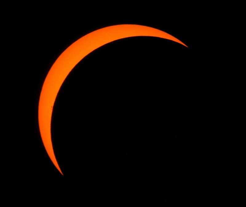 Large yellow crescent over a solid black background.