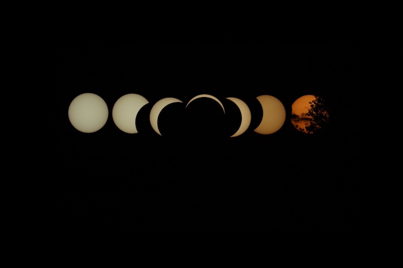A collage with seven crescent suns in a row over a solid black background.