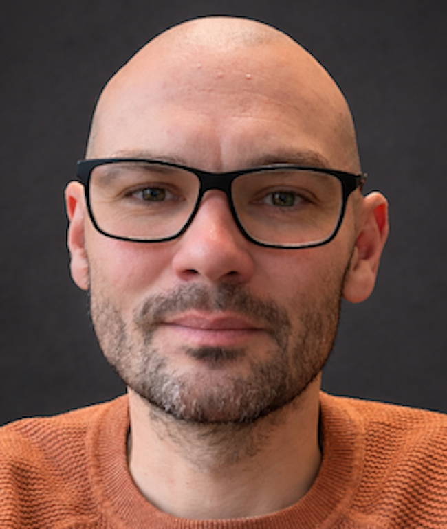 Bald man with eyeglasses and beard.