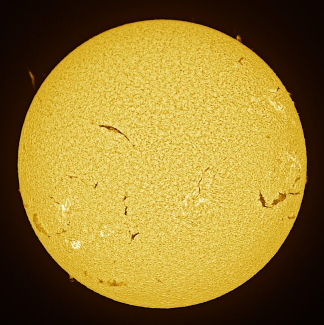 The sun, seen as a large yellow sphere with a mottled surface.