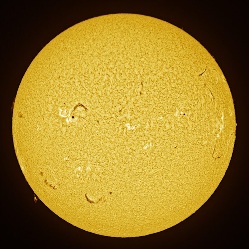 The sun, seen as a large yellow sphere with a mottled surface.