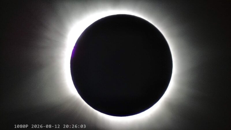 A large black disk surrounded by a luminous aura of white light.
