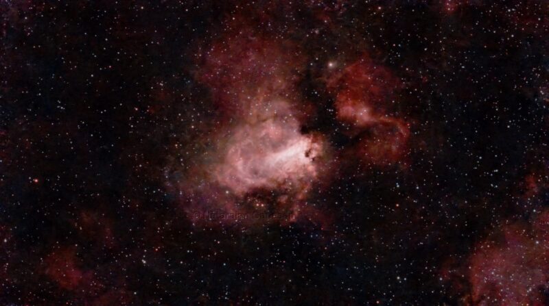 Large, irregular cloud in bright red, with numerous foreground stars.