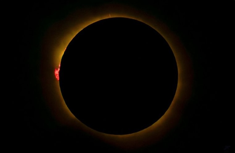 Photo showing a total solar eclipse the moon completely covering the sun, with the sun’s corona visible around the dark lunar disk.