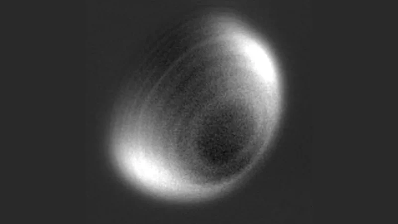 Black-and-white image of Venus reveals rings in the atmosphere.