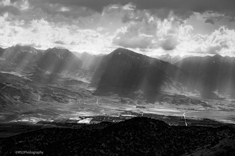 Black and white image showing crepuscular rays over the Sierra mountains.