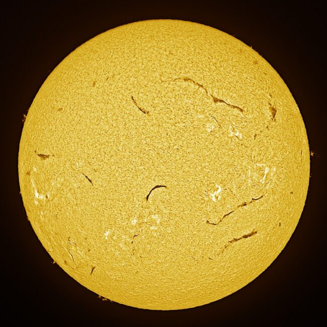 The sun, seen as a large yellow sphere with a mottled surface.