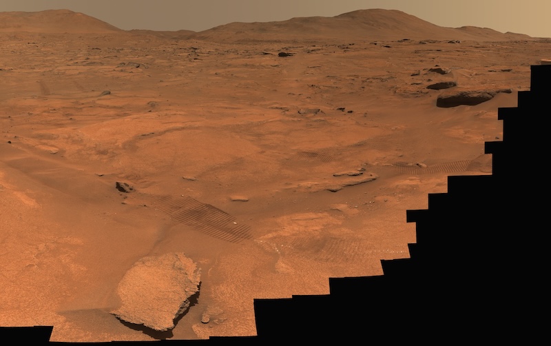Water systems on early Mars: Reddish brown rocky terrain, with 2 areas heavily blacked out.