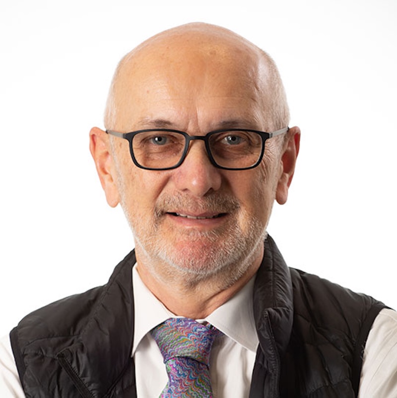Bald man with eyeglasses and colorful tie.