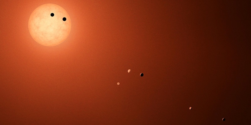 Bright orange sphere at top left, with small orange and black spheres along the diagonal toward lower right. 
