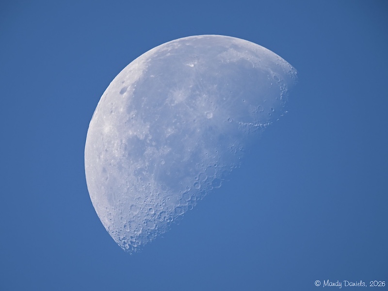 A waning gibbous moon against a blue sky.