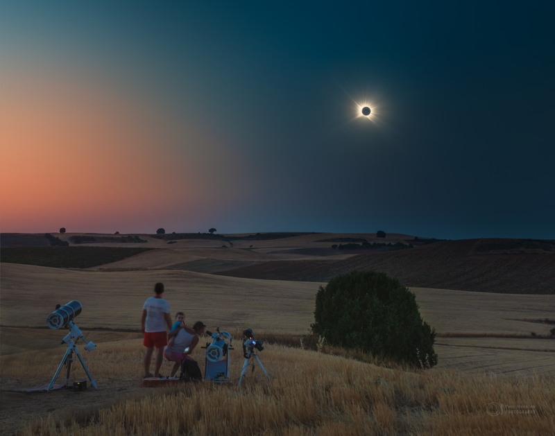 A couple with a young child. They are in a field with many rolling hills. They have several telescopes.