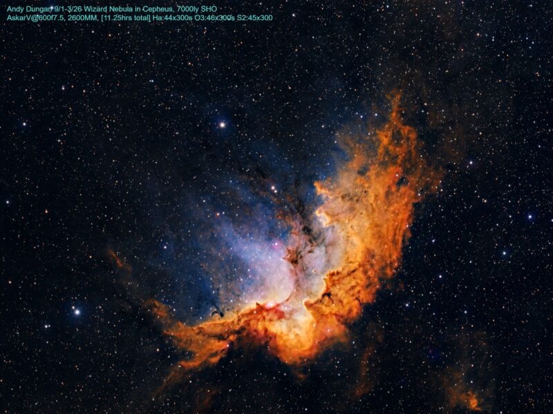 A large, complex, orange mass of gas with blue highlights, dark lanes and numerous foreground stars.